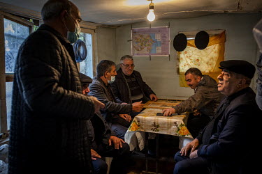 A group of refugees from the Gubadli area of Nagorno Karabakh chat and play backgammon in a small tea shop in Sumgait.