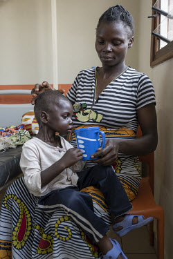 Sahra feeds her acutely malnourished child, Samuel (2.5), with milk at a nutrition treatment centre.