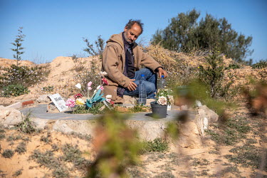Shamseddine Marzouk stands beside the grave of Rose Marie, a young African woman, who drowned when a migrant boat sank off the north African coast. While many migrants are buried anonymously, after DN...