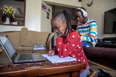 Lisa (6) and Jesse (14) Muchiri follow school lessons via Zoom on their laptops at home while the schools are closed due to the coronavirus pandemic.
