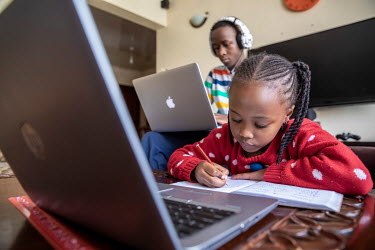 Lisa (6) and Jesse (14) Muchiri follow school lessons via Zoom on their laptops at home while the schools are closed due to the coronavirus pandemic.