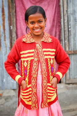 A girl wearing new clothes that were paid for by photographer G.M.B. Akash who is also sponsoring the girl so she has been able to stop labouring work and start to attend school for the first time.