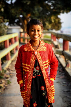 A girl wearing new clothes that were paid for by photographer G.M.B. Akash who is also sponsoring the girl so she has been able to stop labouring work and start to attend school for the first time.