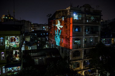 An artist uses an LED projector to display symbols of protest on the side of an apartment block in a show of show support for the the NLD (National League for Democracy), Aung San Suu Kyi and democrac...