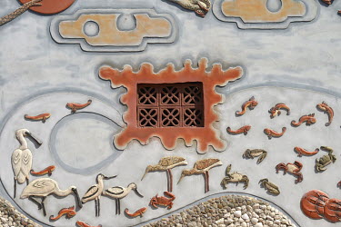 Restored decorative scenes depicting wildlife found in the local wetlands on the exterior wall of a traditional residence in Husia Village.