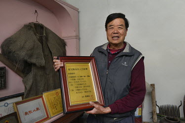 Mr Tung Shui-lun (80), who has lived on Kinmen Island all his life, shows some historical artifacts that belonged to his father inside his ancestral home.