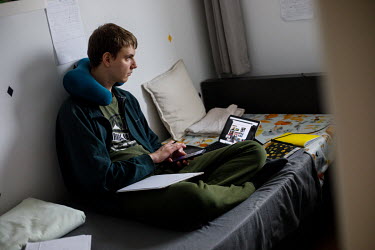 Ignacy, 21, a student at Warsaw University, during his online lessons. All lessons have been online since the pandemic began in March 2020. 'These remote classes are as if each person has been put int...