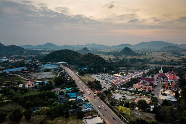 An aerial view of the monastery and Khao Chong Pran Cave, on the right of the road, where tourists and visitors come and watch millions of bats leave their cave roosts and fly out at dusk each night.A...
