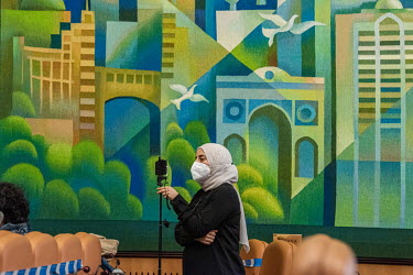 Member of the Syrian opposition communications team filming with a smart phone at a hybrid press conference at the end of a fifth round of UN-sponsored peace talks (the Syrian Constitutional Committee...
