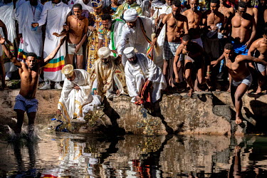As priests bless the water at the Fasiladas Baths during Timkat (a celebration of the baptism of Jesus and the Orthodox Epiphany) pilgrims begin to jump into the water to purify themselves. The offici...