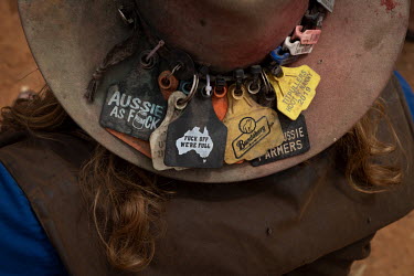 A man wearing an Akubra bush hat, at the Ariah Park, Bachelor and Spinster ball, decorated with an assortment of labels, some from other B&S balls.  Known to locals as simply B&S balls, the events a...