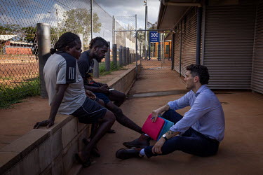 North Australian Aboriginal Justice Agency Lawyer (NAJA) John Blackley talks with clients in the courtyard of the Wadeye police station and courthouse. The courtyard is often filled with family of cli...