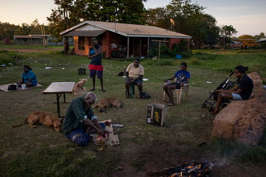 An elderly man prepares a magpie goose, a game bird shot close by to town, while the family watch on. Wadeye residents spend a lot of time outside their homes, cooking and playing as temperatures insi...