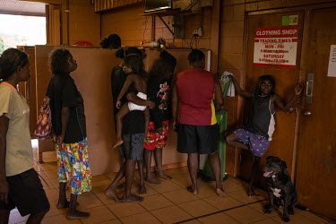 Wadeye residents line up early in the morning on pay day to check money from the basics card, a type of government welfare card only issued to Aboriginal communities, limiting the holder to certain ty...