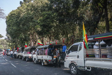 Following the army's takeover of power in a military coup, pro-military supporters arrive in trucks, playing military anthems, at an assembly point prior to a march through the city centre.