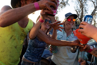 Partygoers prepare a beer / alcohol bong during the Ariah Park Bachelor and Spinster ball.  Known to locals as simply B&S balls, the events are held regularly in rural towns, run by local volunteers...