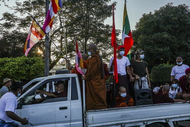 Pro-military supporters, including Buddhist monks, wave flags as dozens of trucks rally around Yangon, a day after the military seized power in a coup.