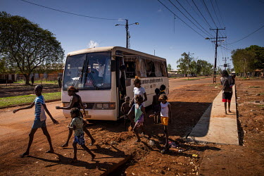 People alight from a council bus that serves the satellite communities on the edges of Wadeye town, helping residents to shop, attend school and access services found in the town. Due to tensions betw...