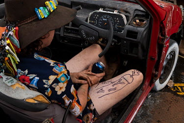 A young man with the images of a penis drawn on his leg with permanent marker pen sits in a wrecked car in a campsite at the Ariah Park Bachelor and Spinster ball.   Known to locals as simply B&S ba...