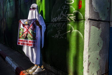 A woman dressed in a 'ghost costume' and holding a placard that reads: 'Shame on you , dictator' in reference to Gen. Min Aung Hlaing, the general who lead the military coup, during demonstrations in...