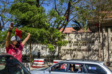 People demonstrate from cars passing in front of the Chinese embassy, where protestors gathered in support for democracy, Aung San Suu Kyi and the National League for Democracy (NLD), and to protest t...