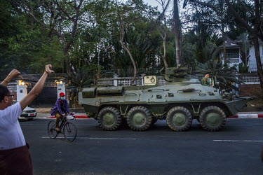 A pedestrian givea 'thumbs down' gesture as an armoured military vehicle drives past him on Sule Pagoda road in the city centre.