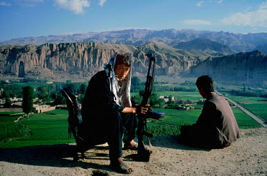 An armed Hazara fighter from the Hesbe-Wahdat-e Islami political group near the site of the Bamiyan Buddha statues (6th-7th century CE) prior to their destruction by the Taliban in 2001.