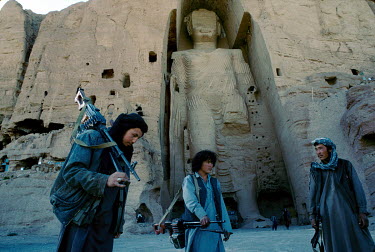 Hazara fighters, from the Hesbe-Wahdat-e Islami political group, stand below the 'Western' Bamiyan Buddha (6th-7th century CE), one of two giant rock-carved Buddha statues , prior to their destruction...