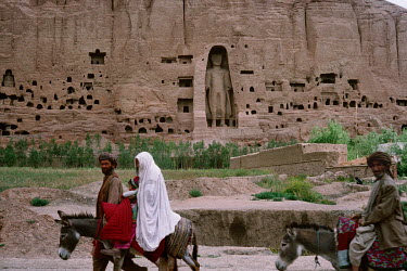 Families ride donkeys past the 'Eastern' Bamiyan Buddha (6th century CE), one of two giant rock-carved Buddha statues, prior to their destruction by the Taliban in 2001.