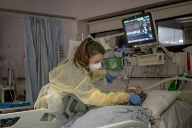 A nurse on duty in the intensive care unit (ICU) at the Homerton Hospital holds a telephone next to the ear of an intubated COVID-19 patient so that her daughter can talk to her. There are currently 2...