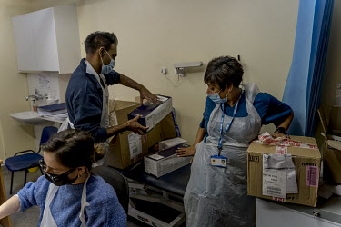 Dr Ammara Hughes (right) unpacks a delivery of Pfizer-BioNTech COVID-19 vaccines and syringes at the Bloomsbury Surgery.Dr Ammara Hughes (right) unpacks a delivery of Pfizer-BioNTech COVID-19 vaccines...