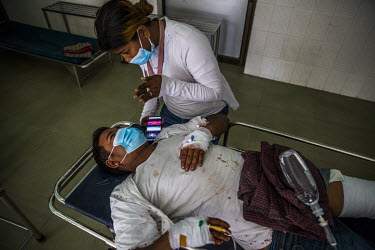Ma Nge talks to her husband Ko Than Tun Aung who is at a clinic where he is being treated after he was shot in the leg with a live round as military and police cracked down on anti-coup protests using...