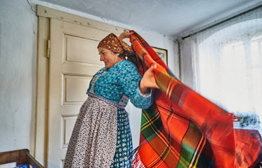Anna Jirovcova, also called Aunt Sasinuc, wraps a shawl around her shoulders at the 'U Bilkuc' historic house. Anna is a member of the Chod folklore group which maintains Chod traditions.Anna Jirovcov...