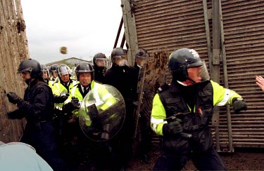 Police charge demonstrators through a hole in the fence at Hill Grove Cat Farm where 800 anti-vivisection protestors tried to break in to the laboratory cat breeding farm.