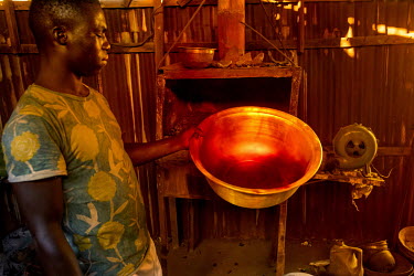Gold residues immersed in sulfuric acid, which gives off red fumes, at a workshop where gold bearing rock and earth is treated with chemicals to release the gold ore.