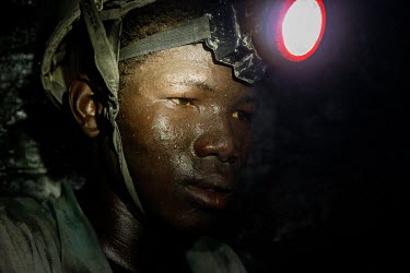 Young Fulani miner digging for gold ore at the bottom of a 112 metre shaft at the Taghabara gold mine.