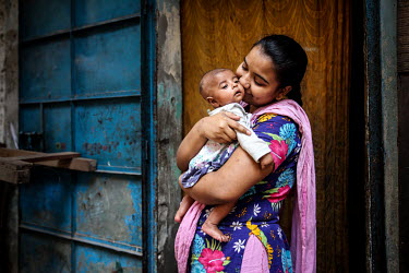 A woman kisses her new born baby in the urban refugee camp popularly known as 'Geneva Camp'. The people living in the area are related to Muslims who moved here mostly, but not exclusively, from Bihar...