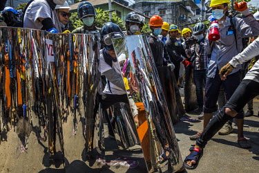 Youth anti-coup protestors practice using their homemade metal shields as they prepare to defend themselves against a violent crack down by police and military joint security forces.