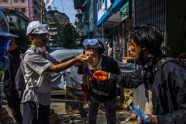 Volunteer medics use Coca-Cola to wash tear gas, fired by security forces, from a protestor's eyes during anti-coup demonstrations in the city centre.