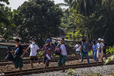 Civilians carry their belongings as they flee the railway staff quarters where security forces have been deployed to carry out a raid aimed at staff who are participating in the Civil Disobedience Mov...