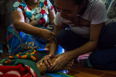 Ma Aye Chan Myint cries as she holds the foot of her dead husband Ko Chit Min Thu (25). He was shot in the head with live ammunition fired by security forces while trying to protect protestors from ru...