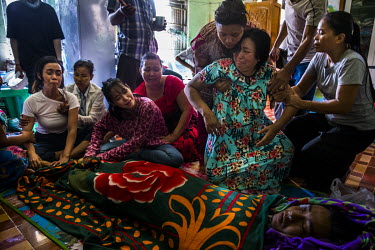 Daw Hnin Mar Lar Aung (mother, right), Aye Myat Thu (sister, centre) and Aye Chan Myint (wife, left) are comforted as they mourn the death of Ko Chit Min Thu (25). He was shot in the head with live am...