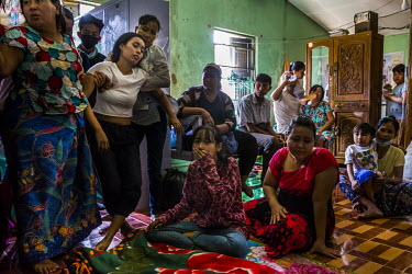 Aye Chan Myint, the wife of Ko Chit Min Thu (25), is supported as she mourns with other family members beside her husband's body. He was shot in the head with live ammunition fired by security forces...