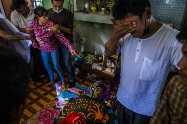Aye Myat Thu, the sister of Ko Chit Min Thu (25) is comforted by relatives as she mourns the death of her brother. He was shot in the head with live ammunition fired by security forces while trying to...