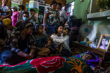 Aye Chan Myint, the wife of Ko Chit Min Thu (25), is comforted by family as she mourns with other relatives beside her husband's body. He was shot in the head with live ammunition fired by security fo...
