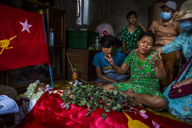 Ma Hnin Wai Oo and her 15-year-old son Chit Min Aung mourn beside the dead body of Ko Aung Aung Zaw (41), a trishaw driver who was shot in the head and killed the previous evening while guarding his n...
