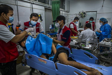 Volunteer medical doctors operate on Htoo Aung (18), an anti-coup protestor wounded during a crackdown on demonstrators by the police and military.