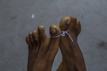 The feet of a dead protestor, brought to a hospital after being shot by security forces, are tied together with a piece of string, a Buddhist tradition for a dead person.