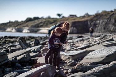 Ellie Farndon looks for ammonites with her mother on the beach at Lyme Regis during a fossil tour with geologist Paddy Howe. The Farndon family came fossil hunting after Ellie heard the story of famou...
