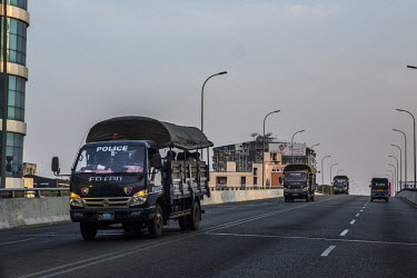 Trucks carrying security forces cross a bridge.